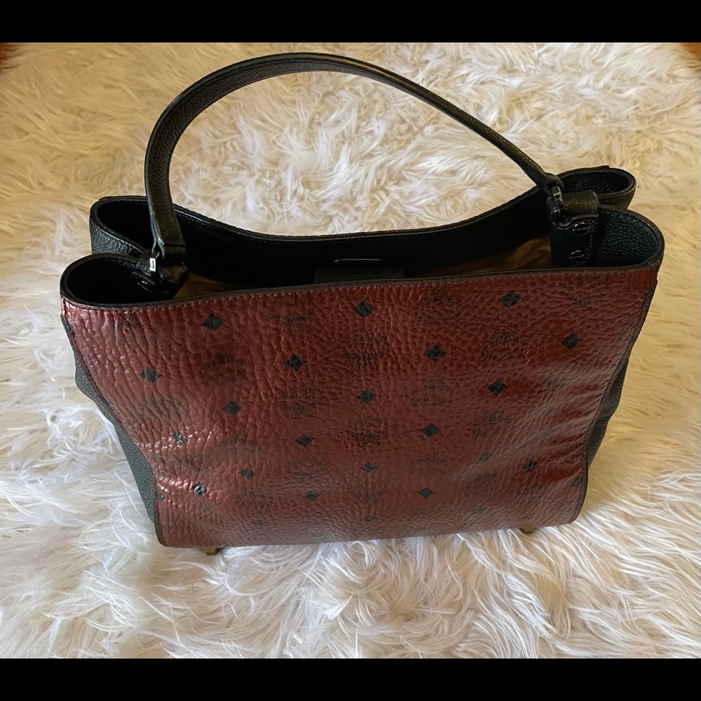 Red Metallic MCM  bag with a black strap.